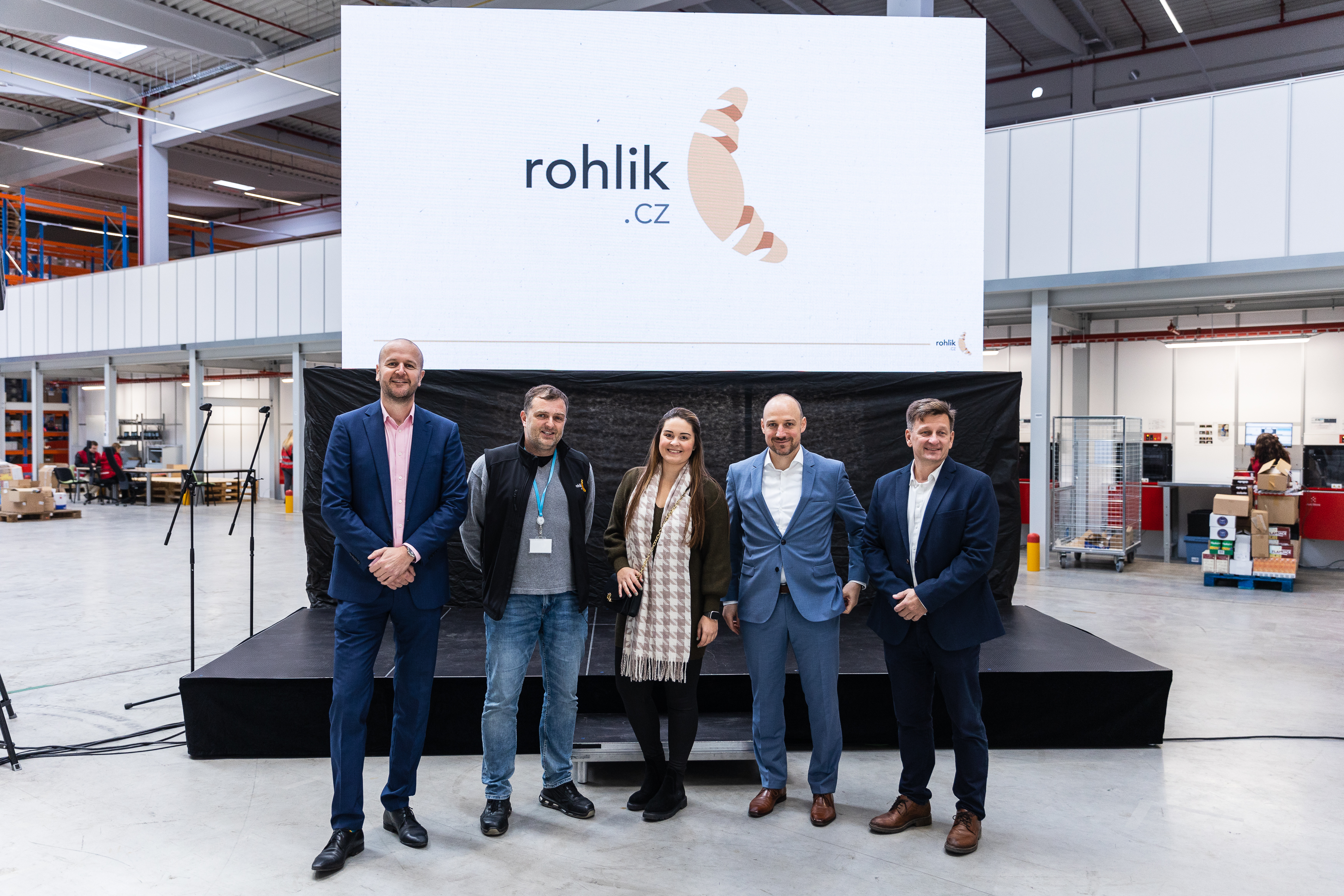 Prologis Czech Team at grand opening of Rohlik.cz BTS Five people stading on stage in the warehouse