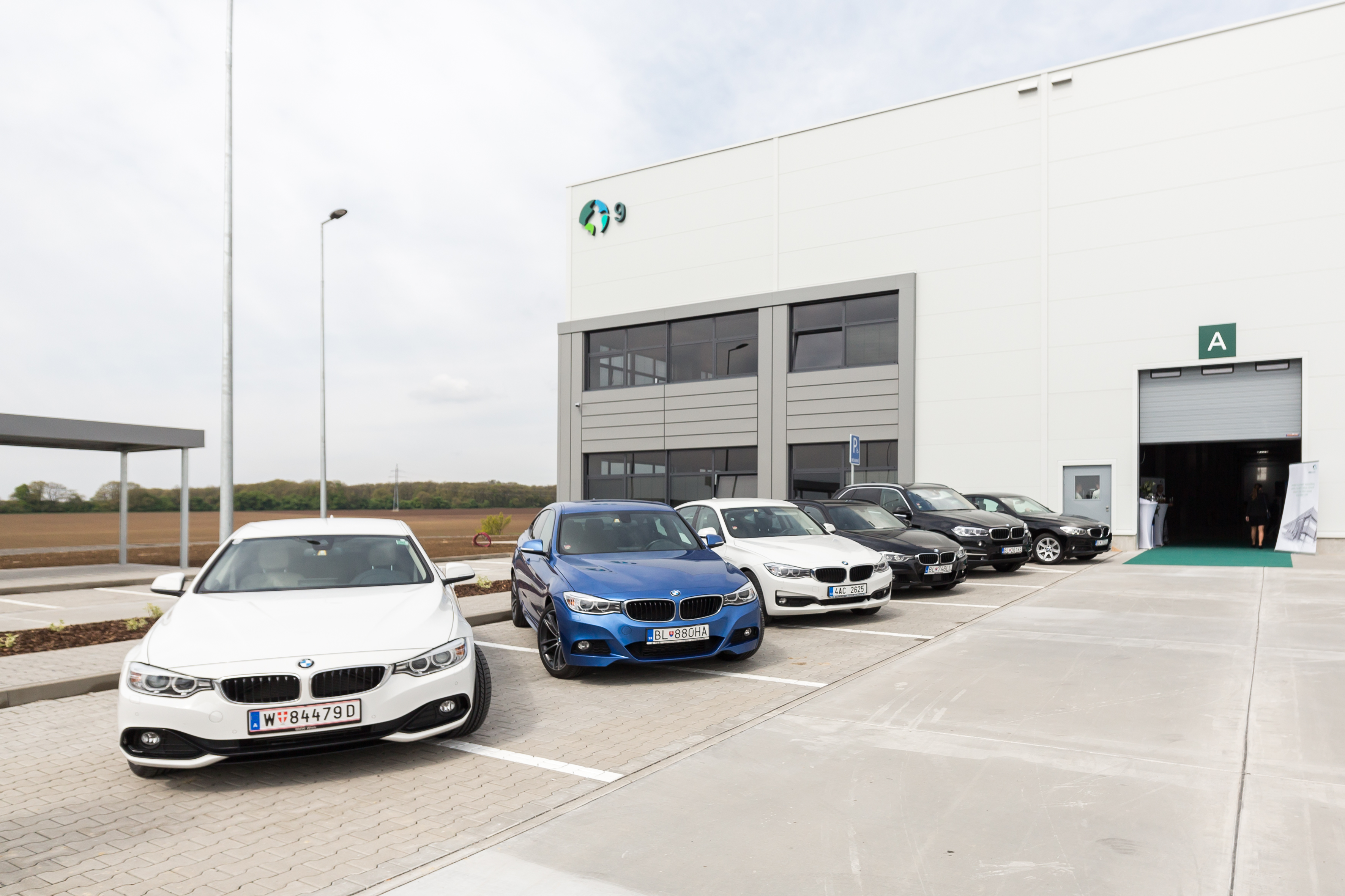 warehouse building with six cars outside