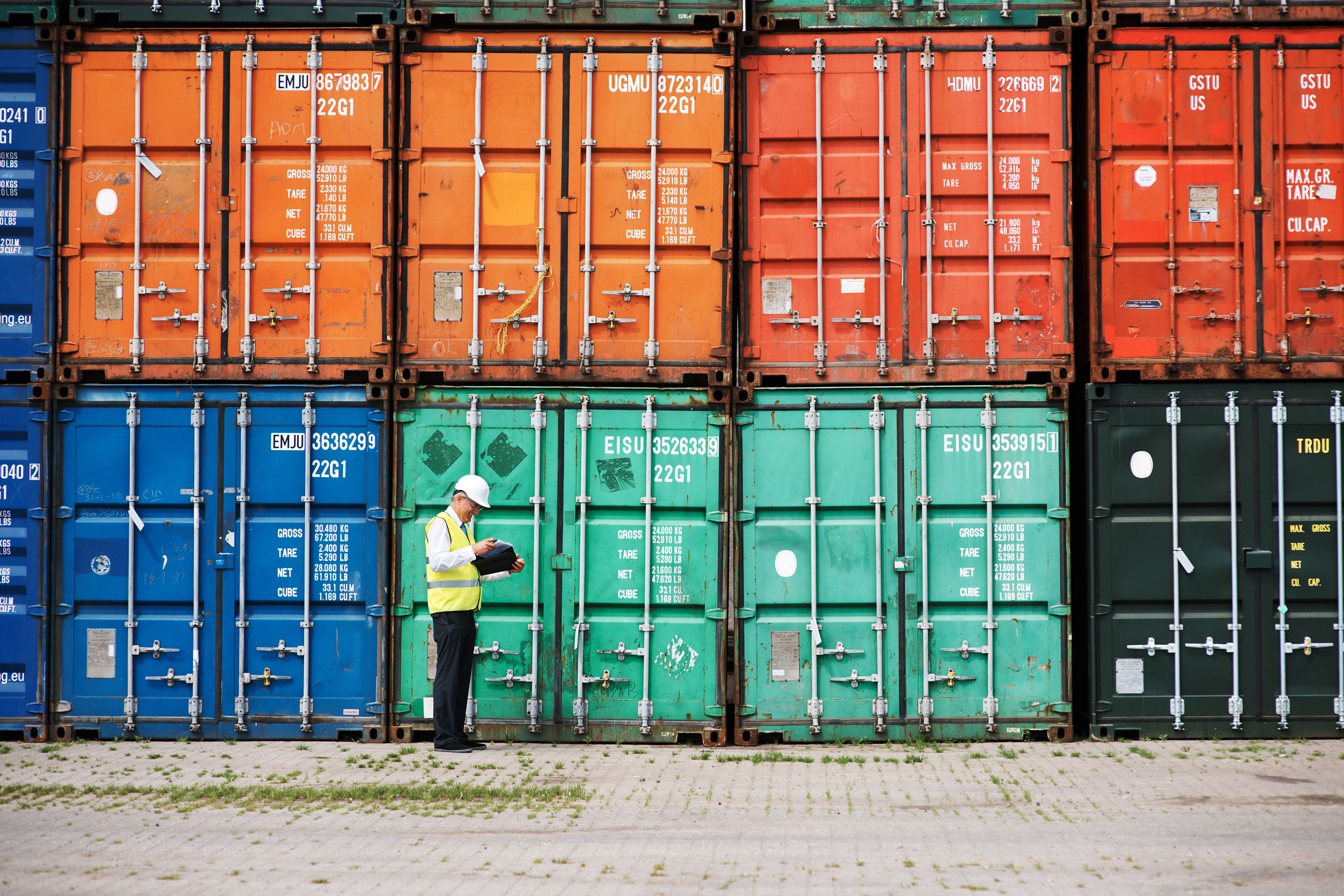 Man standing near shipping containers Man standing near shipping containers