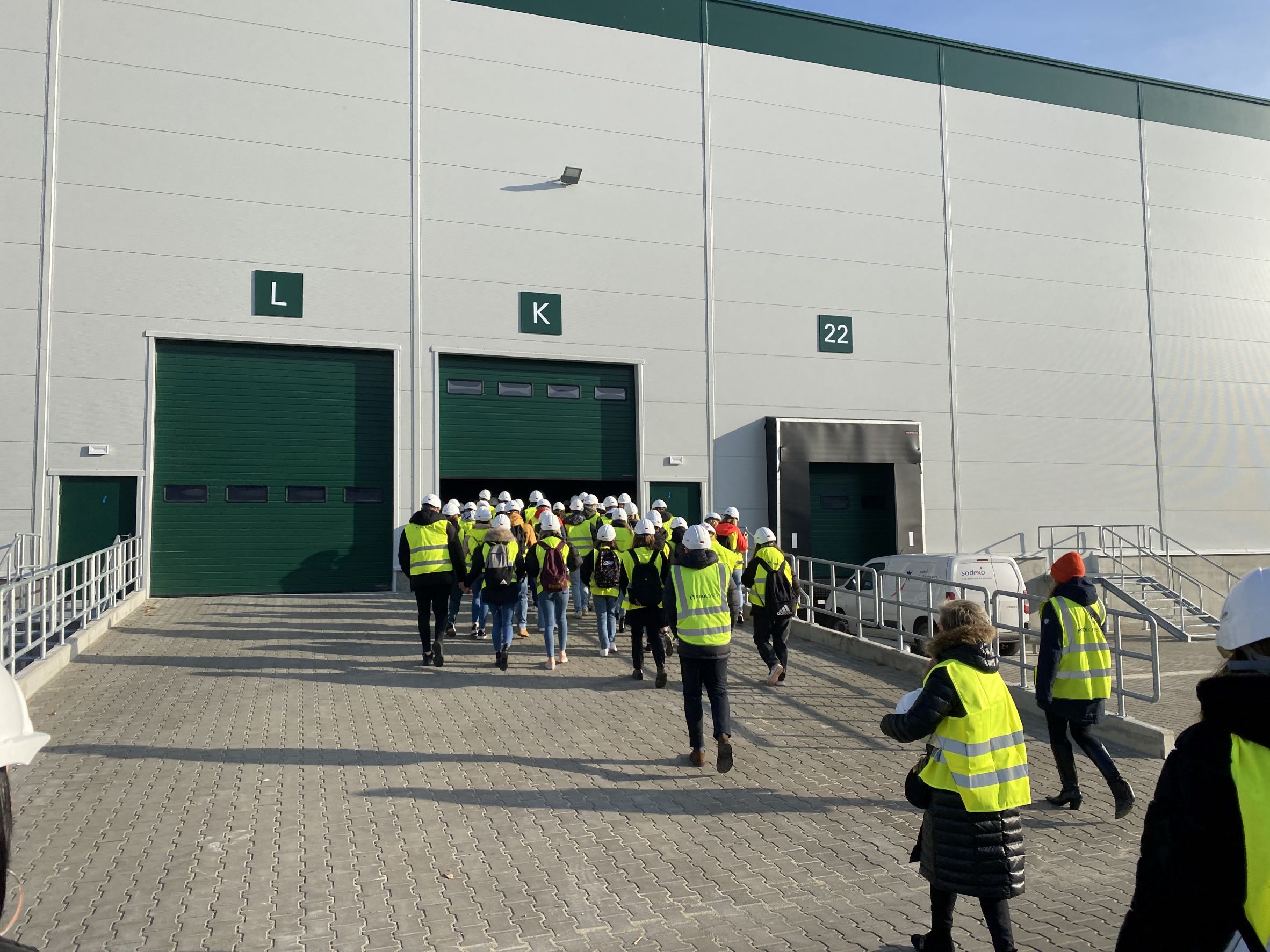 students in reflective vests entering warehouse