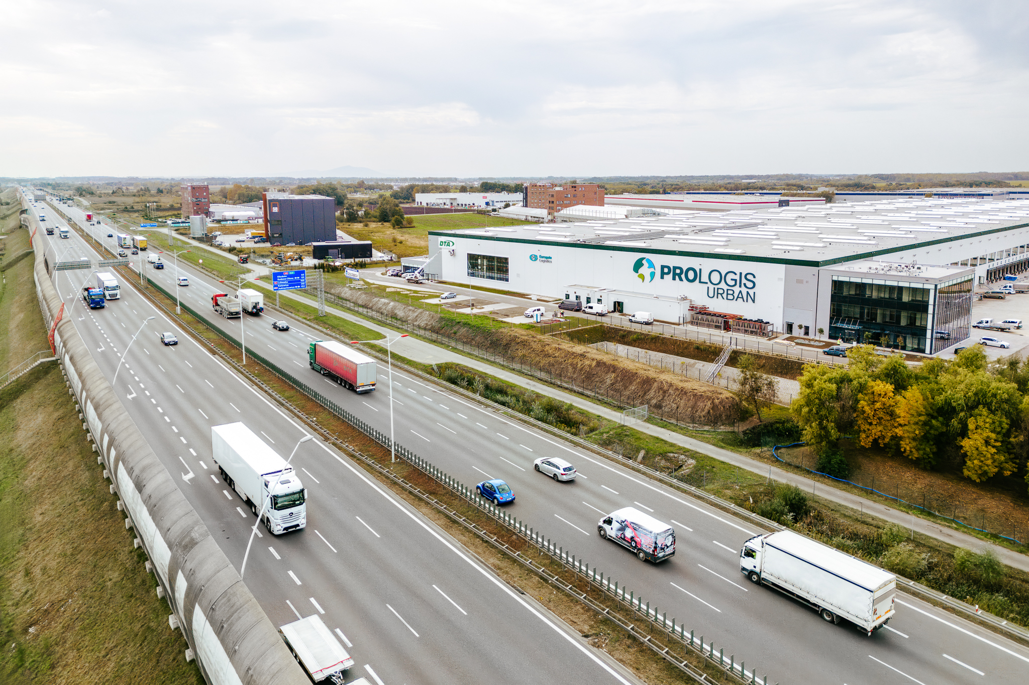 warehouse building with Prologis logo on facade, highway in front fo the facility
