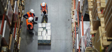 Three workers with a pallet jack in a Prologis warehouse
