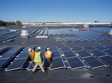 Three Prologis employees working on solar panels