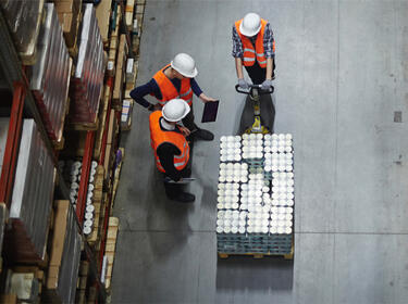 Three workers with a pallet jack in a Prologis warehouse