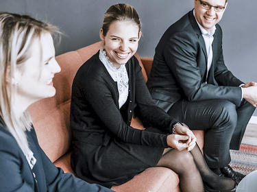 Three team members share a laugh in the Duesseldorf office