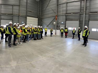 group of students in reflecitve vests inside the warehouse