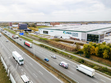 state of the art warehouse with logo Prologis on the facade, highway in front of the building