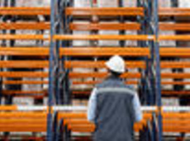 Férfi állt előtte Orange Racking egy raktárban