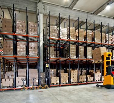 Forklift placing product on a rack in a warehouse Forklift placing product on a rack in a warehouse